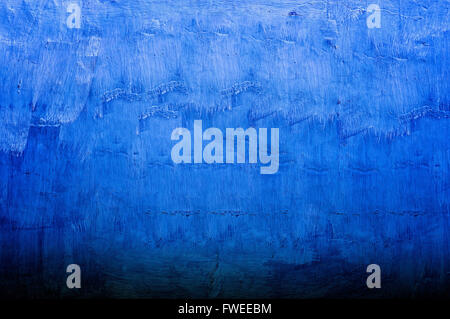 Gradient background texture made from a plastered wall hand painted with visible strokes in shades of blue Stock Photo