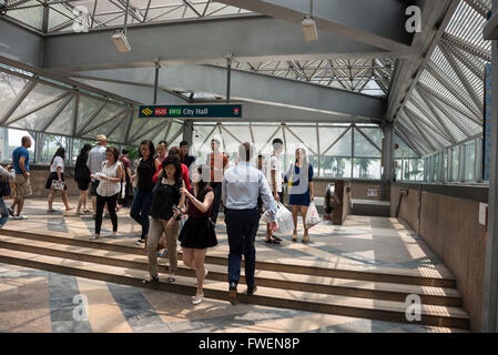 Commuters at City Hall MRT ( Mass Rapid Transit) rail station within the Raffles City shopping mall in Singapore Stock Photo