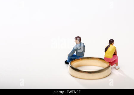 Concept image of a couple sat on wedding rings to illustrate divorce and separation