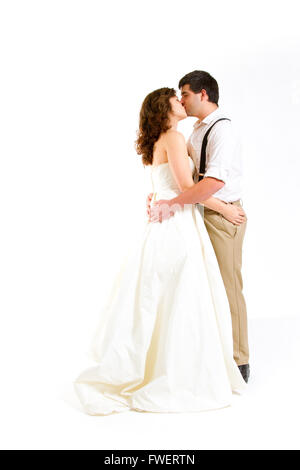 An attractive woman and her handsome husband wear their wedding attire in the studio agains an isolated white background. Stock Photo