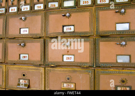 This photo shows the many po boxes at the post office. The mail boxes are lined up in rows and columns for organization. Stock Photo