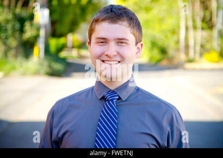 A college student business professional is photographed outside with natural light to create a portrait of a person wearing a gr Stock Photo
