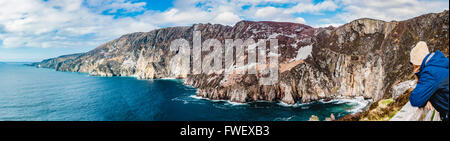 A woman looks out at Slieve League cliffs, Donegal, Ireland, the highest sea cliffs in Ireland. Stock Photo