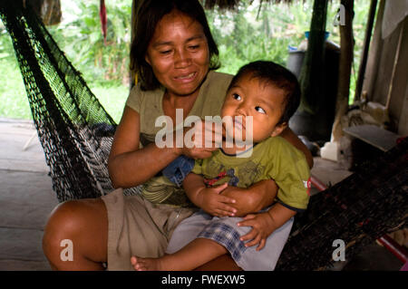 A woman with her child in a hammock in the riverside village of Timicuro I smiling and happy. Iqutios peruvian amazon, Loreto, P Stock Photo