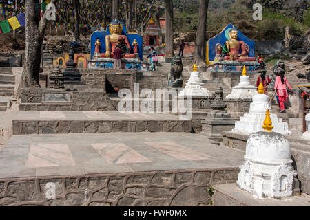 Nepal, Kathmandu, Swayambhunath.  Buddha Statues Flank the Stairs Leading to the Stupa at the top of the Hill. Stock Photo