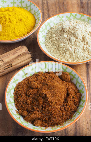 Ground Spices in Bowls with Cinnamon Sticks Stock Photo