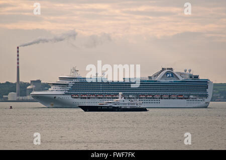 Cruise liner, Emerald Princess, sails past luxury yacht, Air, as she enters Cobh Harbour, Co. Cork, Ireland. Stock Photo