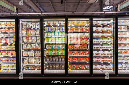 Glass freezer cases of organic and natural frozen foods at a grocery store. Stock Photo