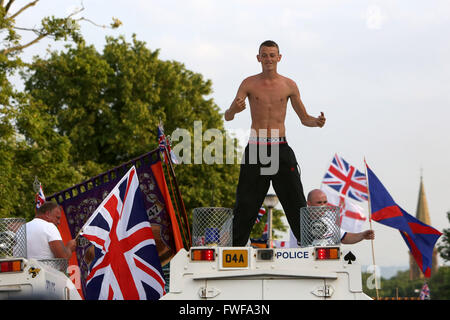 Armed police officers watch Loyalists during trouble in north Belfast after a sustained attack on police in the Woodvale area of Stock Photo