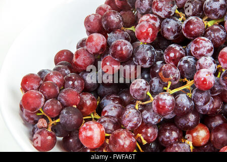 Seedless red grapes many and freshness on white background Stock Photo