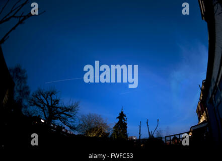 Wimbledon, London, UK. 4th April, 2016. The International Space Station tracks across the sky above London from SW to E at 8:11pm for a period of 6 minutes, shining brightly at dusk from reflected sunlight. The trail passes above the planet Jupiter from right to left (seen in this image). The secondary trail to the right is a passing aircraft. Credit: Malcolm Park/Alamy Live News. Stock Photo