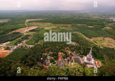 Looking down from Buddhist shrine and statue on top of the mountain towards Tiger Cave Temple (Wat Tham Sua), Krabi, Thailand. T Stock Photo
