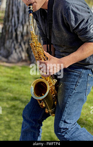 Man playing the saxophone in a park Stock Photo