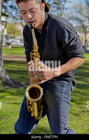 Man playing the saxophone in a park Stock Photo