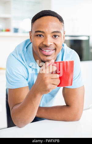 Young man having coffee in kitchen Stock Photo
