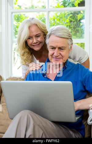 Senior couple using laptop while sitting on at home Stock Photo