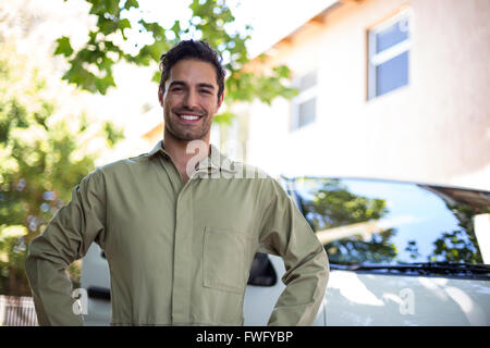 Portrait of smiling pesticide workerwith hand on hip Stock Photo