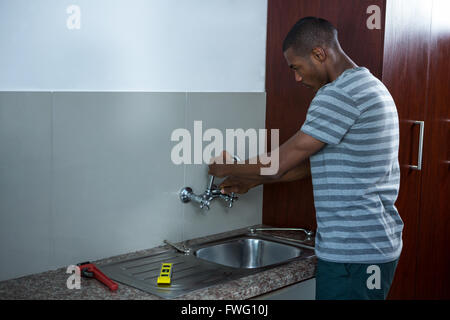 Plumber fixing the sink Stock Photo