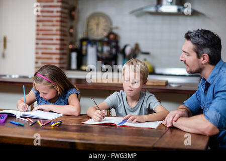 Father helping kids with their homework Stock Photo