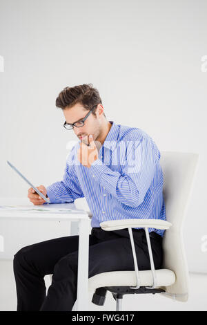 Businessman looking at document and using digital tablet Stock Photo