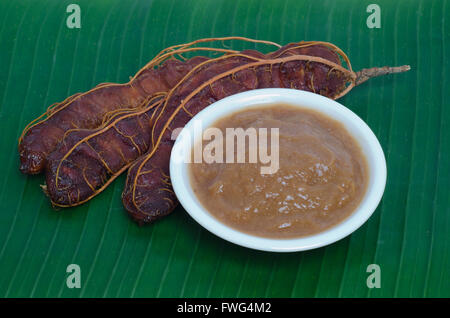 Ripe tamarind and tamarind juice on banana leaf background Stock Photo