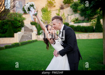 couple bride and groom walking in the park on their wedding day happy Stock Photo