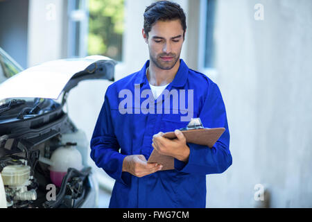 Front view of technician checking clipboard Stock Photo