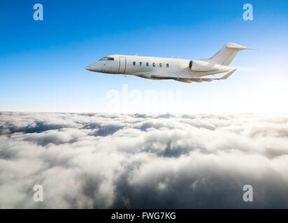 Luxury private jet plane flying above clouds in day light Stock Photo