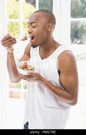 Young man having breakfast cereals Stock Photo