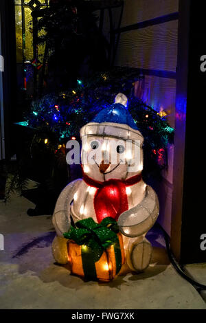 An inflatable snowman Christmas decoration with lights sits on the front porch of a home. USA. Stock Photo