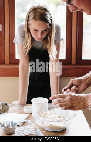 A man and young woman making pastry in a kitchen. Stock Photo