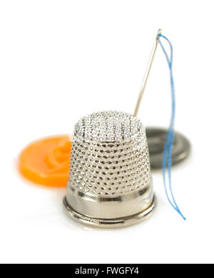 sewing thimble and thread with needle isolated on white background Stock Photo