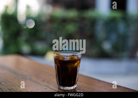 Cold brew iced coffee on wooden table with blurry background