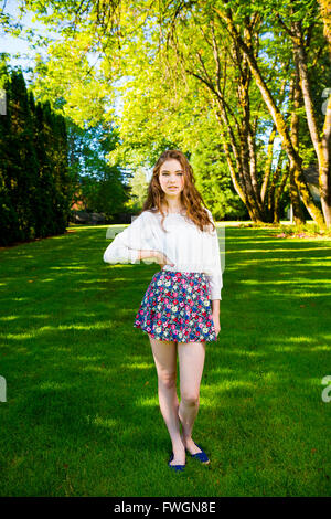 A beautiful young girl poses for a fashion style portrait outdoors at a  park with natural lighting Stock Photo - Alamy