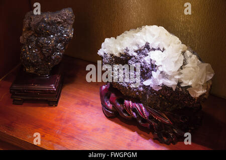Hangzhou, China - December 2, 2014: Natural white quartz crystal cluster on deep purple stone ore Stock Photo