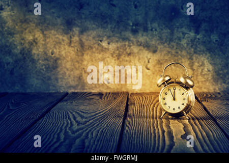 Old alarm clock under beam of light Stock Photo