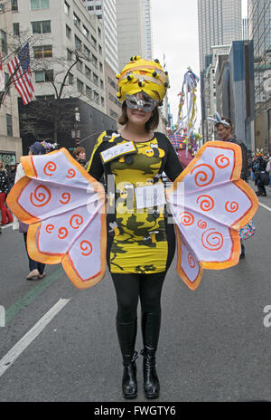 A woman dressed as a bee with a Be Happy sign on Fifth avenue in midtown Manhattan, New York City at the Easter Parade. Stock Photo