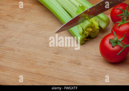 Celery and tomatoes on a cutting board Stock Photo