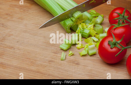 Celery and tomatoes on a cutting board Stock Photo