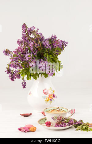 Tea with  lemon and bouquet of  lilac primroses on the table Stock Photo