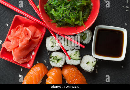 sushi and rolls with green sea salad on a slate table. Stock Photo