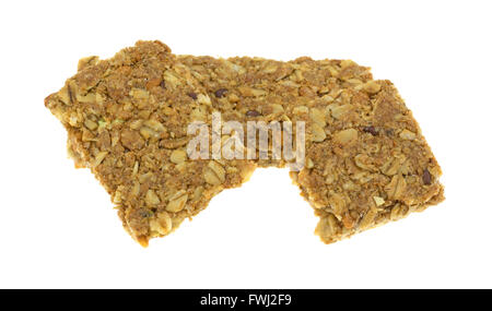 Side view of two cinnamon flavored sesame and pumpkin seed granola bars with one broken isolated on a white background. Stock Photo