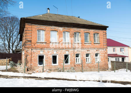 Old brick two-storey house with new plastic windows Stock Photo