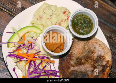 Close Up Of Grilled Pork With Mashed Potatoes, Honey Mustard And Chimichurri Sauce Stock Photo
