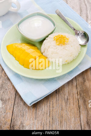 mango and sticky rice with coconut milk wooden table.Thai style tropical dessert Stock Photo