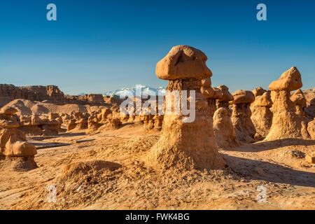 Hoodoo rocks at Goblin Valley State Park, Henry Mountains in distance, Colorado Plateau, Utah, USA Stock Photo