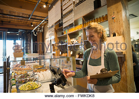 Happy cashier working at the cash register in the supermarket Stock ...