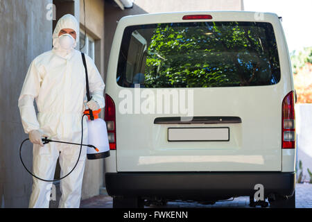 Pest control man standing behind a van Stock Photo