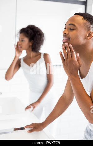 Couple checking their skin in bathroom Stock Photo
