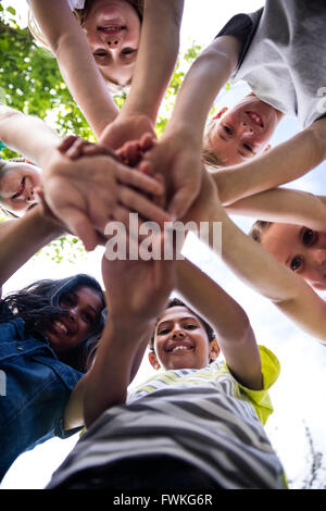 Portrait of happy children putting their hands together Stock Photo - Alamy